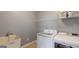 Well-lit laundry room featuring modern appliances, sink, and convenient storage shelving at 104 Conway St, Peachtree City, GA 30269