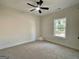 Neutral bedroom with a ceiling fan and view from the window at 6149 Se Pinewood Dr, Covington, GA 30014