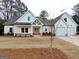 Charming new construction home with white siding, gray roof, and a manicured front yard at 6149 Se Pinewood Dr, Covington, GA 30014