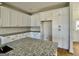 Bright kitchen with white cabinetry, granite counters, and modern fixtures at 6149 Se Pinewood Dr, Covington, GA 30014