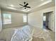 Serene main bedroom featuring tray ceilings, carpet floors, and large windows at 6149 Se Pinewood Dr, Covington, GA 30014