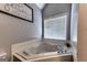 Large bathtub featuring a jacuzzi, gray walls and a window with blinds for natural light at 39 Thorne Berry Dr, Hampton, GA 30228