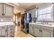Kitchen with gray cabinets, black appliances, and tiled floor, with adjacent dining area and fireplace at 39 Thorne Berry Dr, Hampton, GA 30228