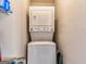 Compact laundry room with stacked washer and dryer and open shelves at 39 Thorne Berry Dr, Hampton, GA 30228