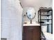 Bathroom showcasing a vanity, an oval mirror, sleek matte fixtures, and stylish shelving for modern elegance at 3140 Cox Cemetery Rd, Social Circle, GA 30025