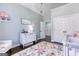 Cozy Bedroom with a white crib, floral rug, white dresser, and an accent chair at 3140 Cox Cemetery Rd, Social Circle, GA 30025