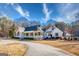 Wide angle of the home's exterior with a circular driveway and large, welcoming porch with white pillars at 3140 Cox Cemetery Rd, Social Circle, GA 30025