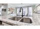 Close-up of granite countertop and kitchen sink, adjacent to a dining area with natural light at 3140 Cox Cemetery Rd, Social Circle, GA 30025