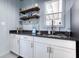 A kitchenette features sleek countertops, white cabinets, and rustic wood shelving at 3140 Cox Cemetery Rd, Social Circle, GA 30025