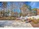 Brick patio features two metal framed lawn chairs with landscaped beds surrounded by woods in the background at 3140 Cox Cemetery Rd, Social Circle, GA 30025