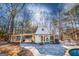 White pool house with covered patio, lounge chairs, and ample space for relaxation next to the pool at 3140 Cox Cemetery Rd, Social Circle, GA 30025