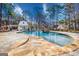 Stunning pool with stone surround, waterfall feature, and adjacent pool house on a wooded lot at 3140 Cox Cemetery Rd, Social Circle, GA 30025