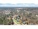 An aerial view shows the landscape, multiple houses, and lake nestled among the trees at 122 Lawn Market, Sharpsburg, GA 30277