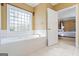 Bright bathroom showcases a large soaking tub under a window at 122 Lawn Market, Sharpsburg, GA 30277