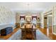 Formal dining room with hardwood floors, decorative wallpaper, and a rustic wooden dining table at 122 Lawn Market, Sharpsburg, GA 30277
