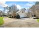 Beautiful home with a well-manicured lawn, mature trees, and paved driveway at 122 Lawn Market, Sharpsburg, GA 30277