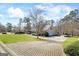 Beautiful home with a well-manicured lawn, mature trees, and brick driveway at 122 Lawn Market, Sharpsburg, GA 30277
