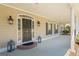 Covered front porch featuring a black front door with side windows and a brick landing at 122 Lawn Market, Sharpsburg, GA 30277