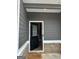 Front door and entryway featuring brick foundation, gray siding, and 'Welcome' doormat at 223 Ivey Ter # 34, Temple, GA 30179
