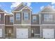 Newly constructed townhome features a brick facade, attached garage, and covered entryway at 223 Ivey Ter # 34, Temple, GA 30179