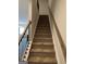 Carpeted staircase leading to the second floor, features a wooden railing and painted risers at 223 Ivey Ter # 34, Temple, GA 30179