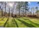 Serene backyard setting with mature trees, featuring an outdoor fire pit and a rustic picnic shelter at 4864 Yeagar Rd, Douglasville, GA 30135