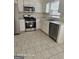 Kitchen with stainless appliances, white cabinets, tile flooring, and a double sink at 11187 Shannon Cir, Hampton, GA 30228