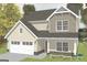 Charming two-story home with a symmetrical design, attached garage, and light colored siding at 11160 Cornerstone Way, Hampton, GA 30228