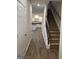 Hallway view leading to staircase and kitchen with white cabinets and stainless appliances at 227 Ivey Ter # 36, Temple, GA 30179