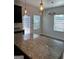 Kitchen island with granite countertop and pendant lights over a bright eating area with lots of light at 229 Ivey Ter # 37, Temple, GA 30179