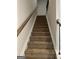 Carpeted staircase with wood railing and white trim at 229 Ivey Ter # 37, Temple, GA 30179