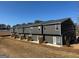 Rear exterior view of townhomes, showcasing multiple units with a shared green space under a clear blue sky at 233 Ivey Ter # 39, Temple, GA 30179