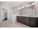 Bathroom featuring double vanity, glass shower with white tile, and wood cabinets at 2443 Sycamore Nw Rd, Atlanta, GA 30318