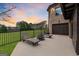 Backyard patio with chaise lounges, fire pit, and iron fence at 1198 Elliot Rd, Mcdonough, GA 30252