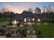 Lovely brick home with manicured lawn, charming entryway, and arched windows at dusk at 1198 Elliot Rd, Mcdonough, GA 30252