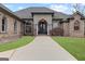 Beautiful brick home featuring an arched doorway, manicured lawn, and a long concrete driveway at 1198 Elliot Rd, Mcdonough, GA 30252