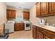 Bright laundry room with wooden cabinetry, sink, and modern washer and dryer units at 1198 Elliot Rd, Mcdonough, GA 30252