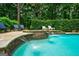 Sparkling backyard pool with stone accents, waterfalls, and lush landscaping creating a private oasis at 5053 Chapel Xing, Douglasville, GA 30135