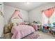 bedroom featuring a canopy bed, vanity, desk, and bookshelf, perfect for play and study at 88 Hardy Water Dr, Lawrenceville, GA 30045