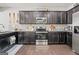 Kitchen features dark cabinetry, stainless steel appliances, granite countertops, and hardwood floors at 88 Hardy Water Dr, Lawrenceville, GA 30045