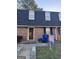 Charming townhome with brick facade, dormer windows and 'For Sale' sign in the front yard at 138 Plantation Cir, Clarkston, GA 30021