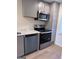 Updated kitchen showcasing stainless steel appliances, light countertops, and stylish gray cabinets at 138 Plantation Cir, Clarkston, GA 30021