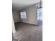 Bright living room features neutral paint, carpet, large windows, and updated lighting at 138 Plantation Cir, Clarkston, GA 30021