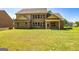 Expansive backyard featuring a covered patio and a view of the rear facade with numerous windows at 204 Shelton Dr, Mcdonough, GA 30252