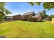 Expansive backyard with lush green grass, mature trees, and home's brick exterior at 204 Shelton Dr, Mcdonough, GA 30252