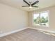 Bright bedroom featuring neutral walls, a large window with backyard views, and a ceiling fan at 204 Shelton Dr, Mcdonough, GA 30252