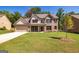 Charming brick home featuring a well-manicured lawn, covered entryway, and a two-car garage at 204 Shelton Dr, Mcdonough, GA 30252