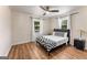 This bedroom has light walls, wood floors, a ceiling fan, and a gray bed frame at 1471 Hardin Ave, College Park, GA 30337