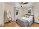 This bedroom features hardwood floors, a ceiling fan, two windows, and a gray upholstered bed at 1471 Hardin Ave, College Park, GA 30337