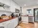 Bright kitchen featuring modern appliances, white cabinetry, wood countertops, and hardwood floors at 1471 Hardin Ave, College Park, GA 30337